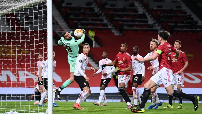 MANCHESTER, ENGLAND - MARCH 11: Gianluigi Donnarumma of A.C. Milan makes a save leading to a missed chance for Harry Maguire of Manchester United during the UEFA Europa League Round of 16 First Leg match between Manchester United and A.C. Milan at Old Trafford on March 11, 2021 in Manchester, England. Sporting stadiums around the UK remain under strict restrictions due to the Coronavirus Pandemic as Government social distancing laws prohibit fans inside venues resulting in games being played behind closed doors. (Photo by Laurence Griffiths/Getty Images)