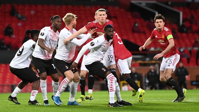 MANCHESTER, ENGLAND - MARCH 11: Scott McTominay of Manchester United battles for possession with Simon Kjaer and Fikayo Tomori of A.C. Milan during the UEFA Europa League Round of 16 First Leg match between Manchester United and A.C. Milan at Old Trafford on March 11, 2021 in Manchester, England. Sporting stadiums around the UK remain under strict restrictions due to the Coronavirus Pandemic as Government social distancing laws prohibit fans inside venues resulting in games being played behind closed doors. (Photo by Laurence Griffiths/Getty Images)