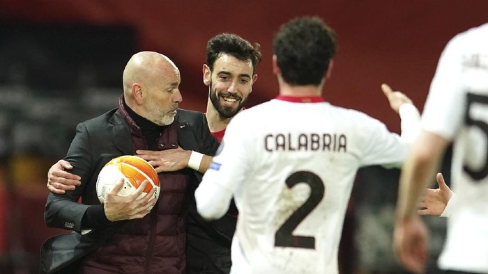 AC Milans manager Stefano Pioli, left, and Manchester Uniteds Bruno Fernandes during the Europa League round of 16 first leg soccer match between Manchester United and AC Milan at Old Trafford in Manchester, England, Thursday, March 11, 2021. (AP Photo/Dave Thompson)