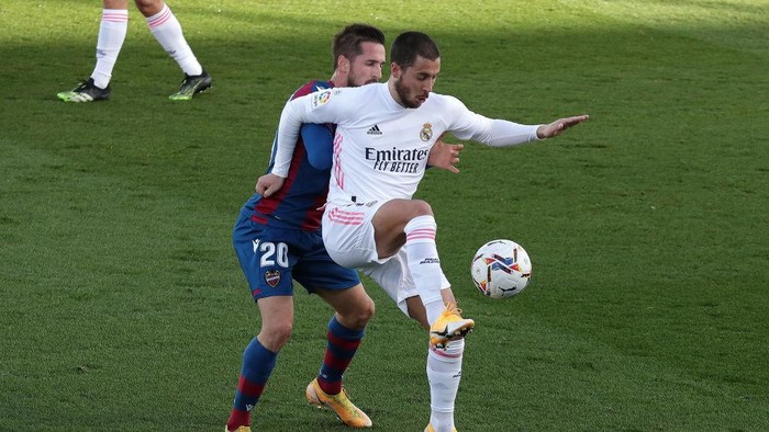 MADRID, SPAIN - JANUARY 30: Eden Hazard of Real Madrid is challenged by Jorge Miramon of Levante UD during the La Liga Santander match between Real Madrid and Levante UD at Estadio Alfredo Di Stefano on January 30, 2021 in Madrid, Spain. Sporting stadiums around Spain remain under strict restrictions due to the Coronavirus Pandemic as Government social distancing laws prohibit fans inside venues resulting in games being played behind closed doors. (Photo by Gonzalo Arroyo Moreno/Getty Images)