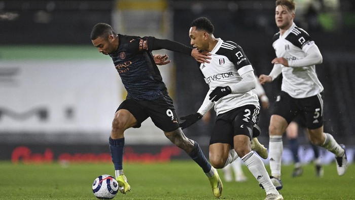 Manchester Citys Gabriel Jesus, left holds off Fulhams Kenny Tete during an English Premier League soccer match between Fulham and Manchester City at the Craven Cottage stadium in London, England, Saturday March 13, 2021. (Justin Setterfield/Pool via AP)
