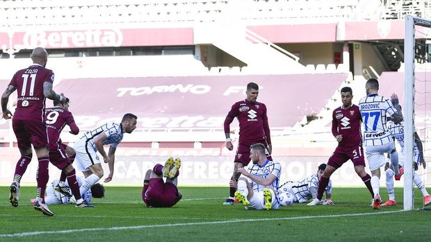 Torino's Antonio Sanabria, left, partially covered, scores his team's first goal during the Italian Serie A soccer match between Torino and Inter Milan at the Olimpico Grande Torino stadium in Turin, Italy, Sunday, March 14, 2021 (Fabio Ferrari / LaPresse via AP)