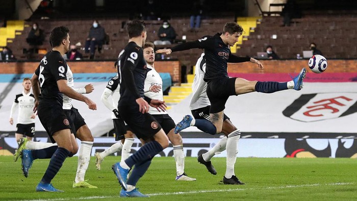LONDON, ENGLAND - MARCH 13: John Stones of Manchester City scores their teams first goal during the Premier League match between Fulham and Manchester City at Craven Cottage on March 13, 2021 in London, England. Sporting stadiums around the UK remain under strict restrictions due to the Coronavirus Pandemic as Government social distancing laws prohibit fans inside venues resulting in games being played behind closed doors. (Photo by Catherine Ivill/Getty Images)