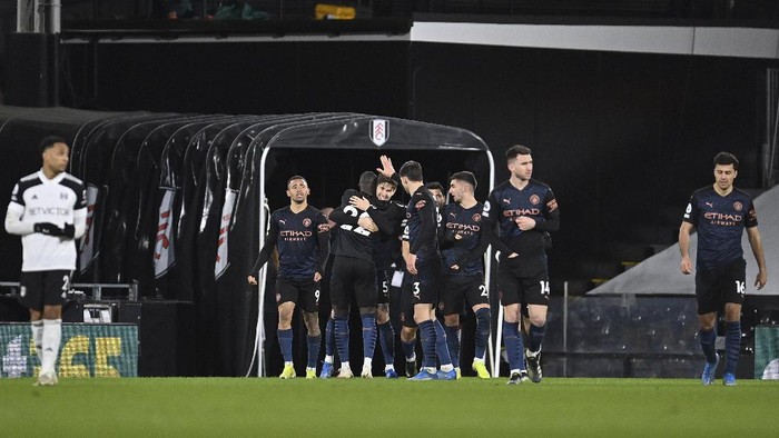 Manchester Citys John Stones, centre, celebrates with team mates after scoring his sides opening goal during an English Premier League soccer match between Fulham and Manchester City at the Craven Cottage stadium in London, England, Saturday March 13, 2021. (Justin Setterfield/Pool via AP)