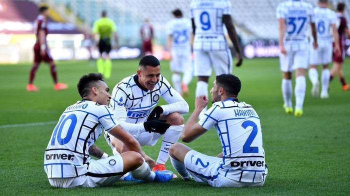 TURIN, ITALY - MARCH 14: Lautaro Martinez (L) of Internazionale celebrates with team mates (L - R) Alexis Sanchez and Achraf Hakimi after scoring their sides second goal during the Serie A match between Torino FC  and FC Internazionale at Stadio Olimpico di Torino on March 14, 2021 in Turin, Italy. Sporting stadiums around Italy remain under strict restrictions due to the Coronavirus Pandemic as Government social distancing laws prohibit fans inside venues resulting in games being played behind closed doors. (Photo by Valerio Pennicino/Getty Images)