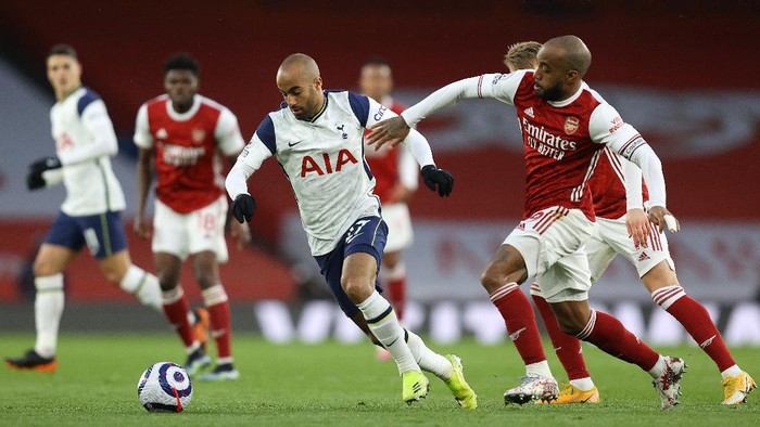 LONDON, ENGLAND - MARCH 14: Lucas Moura of Tottenham Hotspur is challenged by Alexandre Lacazette of Arsenal during the Premier League match between Arsenal and Tottenham Hotspur at Emirates Stadium on March 14, 2021 in London, England. Sporting stadiums around the UK remain under strict restrictions due to the Coronavirus Pandemic as Government social distancing laws prohibit fans inside venues resulting in games being played behind closed doors. (Photo by Julian Finney/Getty Images)