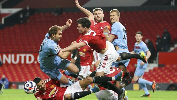 West Ham's Craig Dawson, left, and Manchester United's Harry Maguire compete for the ball during the English Premier League soccer match between Manchester United and West Ham United at Old Trafford, Manchester, England, Sunday, March. 14, 2021. (AP Photo/Clive Brunskill,Pool)