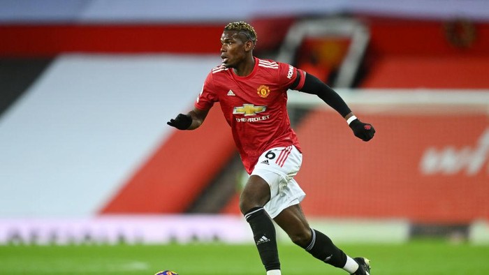 MANCHESTER, ENGLAND - FEBRUARY 06: Paul Pogba of Manchester United runs with the ball during the Premier League match between Manchester United and Everton at Old Trafford on February 06, 2021 in Manchester, England. Sporting stadiums around the UK remain under strict restrictions due to the Coronavirus Pandemic as Government social distancing laws prohibit fans inside venues resulting in games being played behind closed doors. (Photo by Michael Regan/Getty Images)
