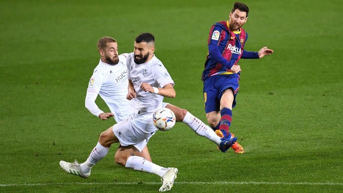 BARCELONA, SPAIN - MARCH 15: Lionel Messi of FC Barcelona scores their sides fourth goal during the La Liga Santander match between FC Barcelona and SD Huesca at Camp Nou on March 15, 2021 in Barcelona, Spain. Sporting stadiums around Spain remain under strict restrictions due to the Coronavirus Pandemic as Government social distancing laws prohibit fans inside venues resulting in games being played behind closed doors. (Photo by David Ramos/Getty Images)