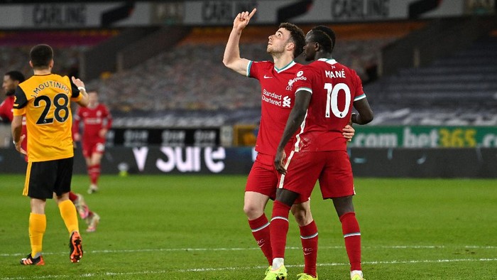 WOLVERHAMPTON, ENGLAND - MARCH 15: Diogo Jota of Liverpool celebrates with team mate Sadio Mane after scoring their sides first goal during the Premier League match between Wolverhampton Wanderers and Liverpool at Molineux on March 15, 2021 in Wolverhampton, England. Sporting stadiums around the UK remain under strict restrictions due to the Coronavirus Pandemic as Government social distancing laws prohibit fans inside venues resulting in games being played behind closed doors. (Photo by Paul Ellis - Pool/Getty Images)