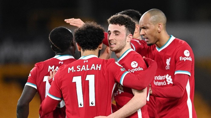 WOLVERHAMPTON, ENGLAND - MARCH 15: Diogo Jota of Liverpool celebrates with Fabinho and team mates after scoring their sides first goal during the Premier League match between Wolverhampton Wanderers and Liverpool at Molineux on March 15, 2021 in Wolverhampton, England. Sporting stadiums around the UK remain under strict restrictions due to the Coronavirus Pandemic as Government social distancing laws prohibit fans inside venues resulting in games being played behind closed doors. (Photo by Laurence Griffiths/Getty Images)
