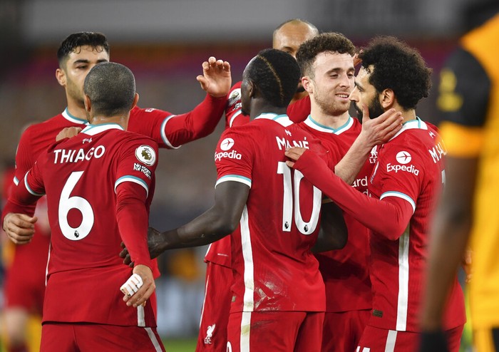 Liverpools Diogo Jota, second right, celebrates with teammate Mohamed Salah, right, after scoring his teams first goal during the English Premier League soccer match between Wolverhampton Wanderers and Liverpool at Molineux Stadium in Wolverhampton, England, Monday, March. 15, 2021. (AP Photo/Paul Ellis,Pool)