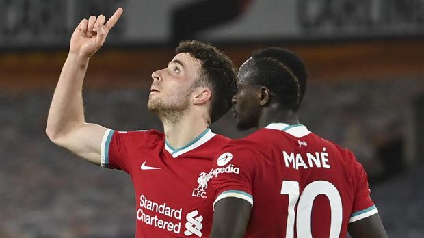 Liverpool's Diogo Jota, left, celebrates as he is congratulated by teammate Sadio Mane after scoring his team's first goal during the English Premier League soccer match between Wolverhampton Wanderers and Liverpool at Molineux Stadium in Wolverhampton, England, Monday, March. 15, 2021. (AP Photo/Paul Ellis,Pool)