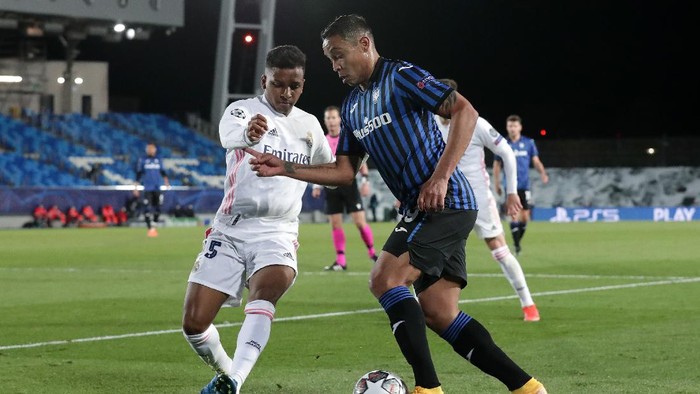 MADRID, SPAIN - MARCH 16: Luis Muriel of Atalanta BC  is put under pressure by Rodrygo of Real Madrid during the UEFA Champions League Round of 16 match between Real Madrid and Atalanta at Estadio Alfredo Di Stefano on March 16, 2021 in Madrid, Spain. Sporting stadiums around Spain remain under strict restrictions due to the Coronavirus Pandemic as Government social distancing laws prohibit fans inside venues resulting in games being played behind closed doors. (Photo by Gonzalo Arroyo Moreno/Getty Images)