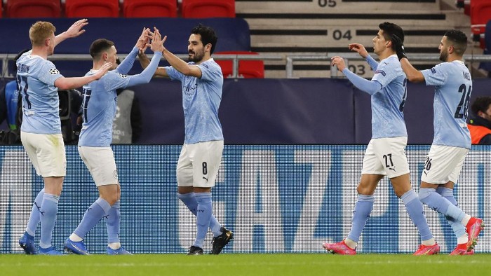 Manchester Citys Ilkay Gundogan, centre, is congratulated by teammates after scoring his teams second goal during the Champions League round of 16 second leg soccer match between Manchester City and Borussia Moenchengladbach at the Puskas Arena in Budapest, Hungary, Tuesday, March 16, 2021. (AP Photo/Laszlo Balogh)