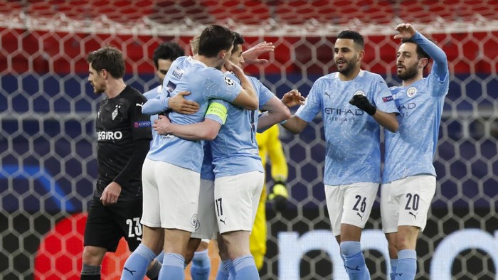 Manchester Citys Kevin De Bruyne, obscured, is congratulated by teammates after scoring his teams first goal during the Champions League round of 16 second leg soccer match between Manchester City and Borussia Moenchengladbach at the Puskas Arena in Budapest, Hungary, Tuesday, March 16, 2021. (AP Photo/Laszlo Balogh)
