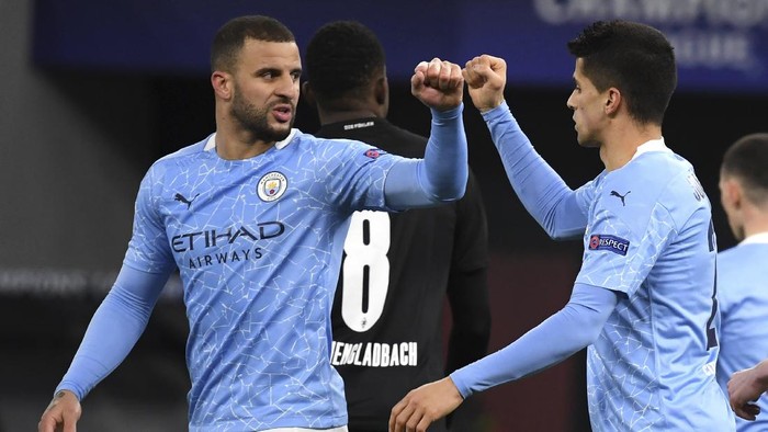 Manchester Citys Kyle Walker, left, and teammate Joao Cancelo celebrate after a goal, during the Champions League round of 16 second leg soccer match between Manchester City and Borussia Moenchengladbach in the Puskas Ferenc Arena, Budapest, Hungary, Tuesday, March 16, 2021. (Tibor Illyes/MTI via AP)