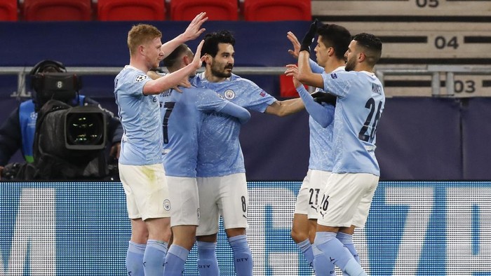 Manchester Citys Ilkay Gundogan, centre, is congratulated by teammates after scoring his teams second goal during the Champions League round of 16 second leg soccer match between Manchester City and Borussia Moenchengladbach at the Puskas Arena in Budapest, Hungary, Tuesday, March 16, 2021. (AP Photo/Laszlo Balogh)