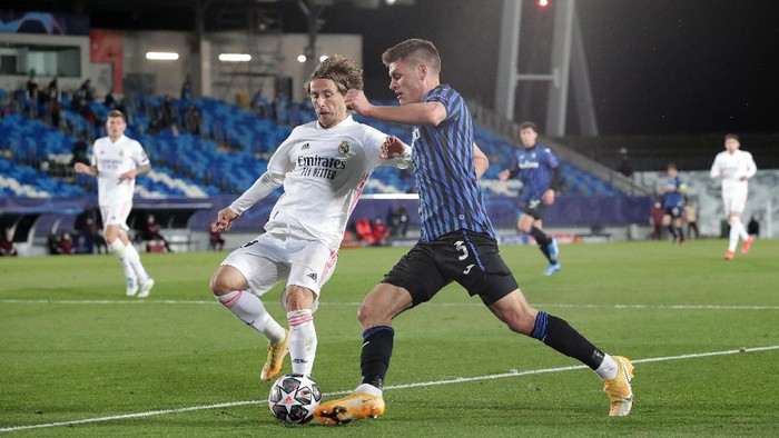 MADRID, SPAIN - MARCH 16: Joakim Maehle of Atalanta BC  is put under pressure by Luka Modric of Real Madrid during the UEFA Champions League Round of 16 match between Real Madrid and Atalanta at Estadio Alfredo Di Stefano on March 16, 2021 in Madrid, Spain. Sporting stadiums around Spain remain under strict restrictions due to the Coronavirus Pandemic as Government social distancing laws prohibit fans inside venues resulting in games being played behind closed doors. (Photo by Gonzalo Arroyo Moreno/Getty Images)