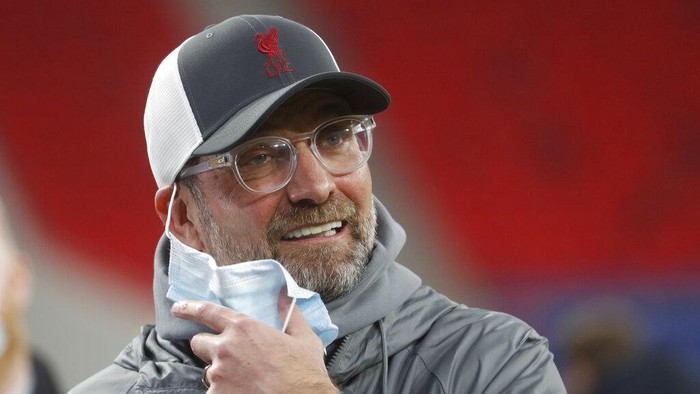 Liverpools manager Jurgen Klopp removes his face mask ahead of the Champions League round of 16 second leg soccer match between Liverpool and Leipzig at the Puskas Arena stadium in Budapest, Hungary, Wednesday, March 10, 2021. (AP Photo/Laszlo Balogh)