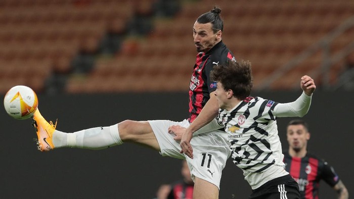 MILAN, ITALY - MARCH 18:  Zlatan Ibrahimovic of AC Milan jumps for the ball against Victor Lindelof of Manchester United during the UEFA Europa League Round of 16 Second Leg match between AC Milan and Manchester United at San Siro on March 18, 2021 in Milan, Italy. Sporting stadiums around Europe remain under strict restrictions due to the Coronavirus Pandemic as Government social distancing laws prohibit fans inside venues resulting in games being played behind closed doors. (Photo by Emilio Andreoli/Getty Images)