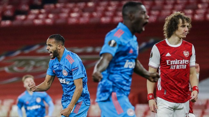 Olympiacos Youssef El-Arabi, left, celebrates after scoring the opening goal during the Europa League, round of 16, second leg soccer match between Arsenal and Olympiacos at the Emirates Stadium, in London, Thursday, March 18, 2021. (AP Photo/Matt Dunham)