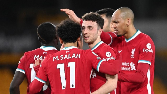 WOLVERHAMPTON, ENGLAND - MARCH 15: Diogo Jota of Liverpool celebrates with Fabinho and team mates after scoring their sides first goal during the Premier League match between Wolverhampton Wanderers and Liverpool at Molineux on March 15, 2021 in Wolverhampton, England. Sporting stadiums around the UK remain under strict restrictions due to the Coronavirus Pandemic as Government social distancing laws prohibit fans inside venues resulting in games being played behind closed doors. (Photo by Laurence Griffiths/Getty Images)