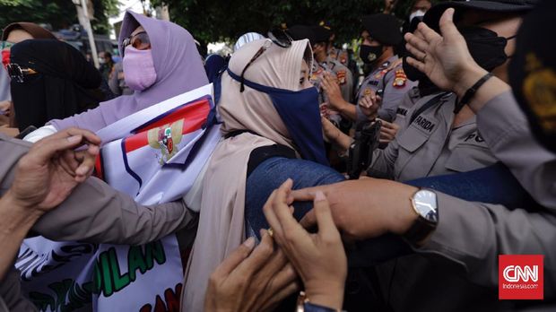 Aparat kepolisian membubarkan paksa sejumlah massa dan simpatisan eks Imam Besar Front Pembela Islam (FPI) Rizieq Shihab di Pengadilan Negeri Jakarta Timur, Jumat, 19 Maret 2021. CNN Indonesia/Adhi Wicaksono