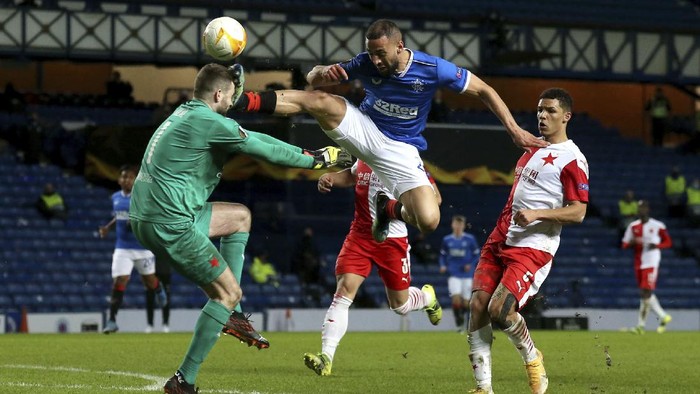 Rangers Kemar Roofe, centre, kicks Slavia Pragues Ondrej Kolar, during the Europa League Round of Sixteen soccer match between Rangers and Slavia Prague, at Ibrox Stadium, in Glasgow, Scotland,  Thursday March 18, 2021. (Andrew Milligan/PA via AP)