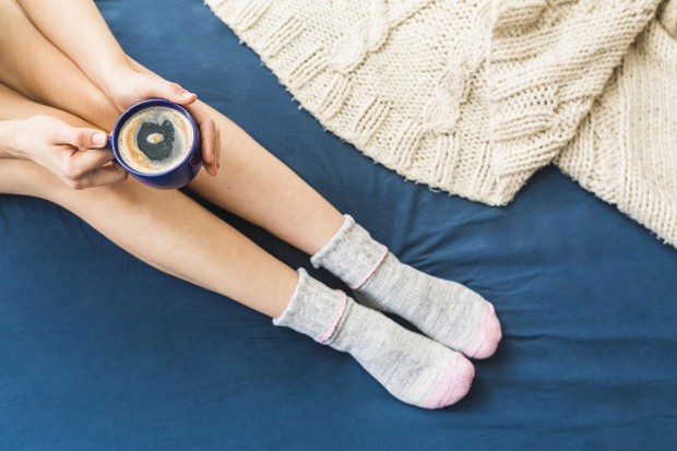 Memakai kaos kaki saat tidur untuk membantu rawat tumit kaki.