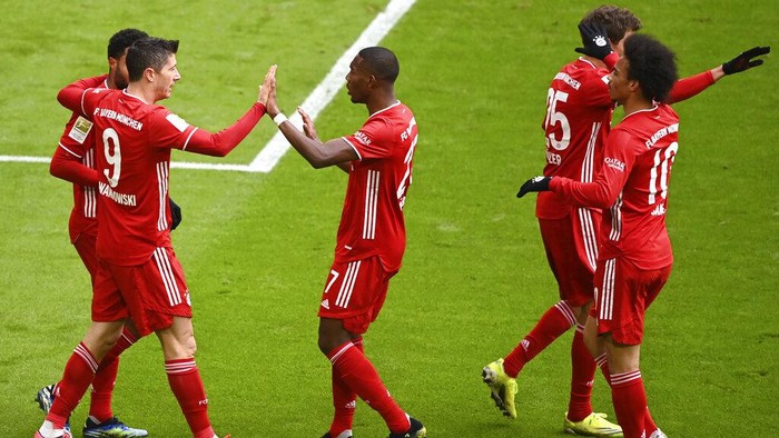 Bayerns Robert Lewandowski, left, celebrates with teammates after scoring his sides first goal during the German Bundesliga soccer match between FC Bayern Munich and VfB Stuttgart in Munich, Germany, Saturday, March 20, 2021. (Matthias Balk/Pool via AP)