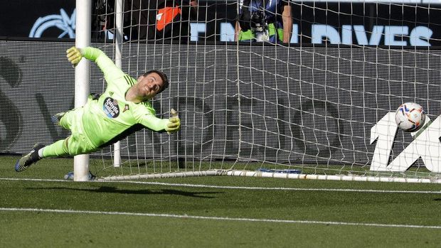 Celta de Vigo goalkeeper Iván Villar takes a dive but fails to stop Real Madrid's Karim Benzema's first goal during a Spanish League match between Celta and Real Madrid at Balaidos Stadium in Vigo, Spain , on Saturday, March 20, 2021 (AP Photo / Lalo R. Villar)