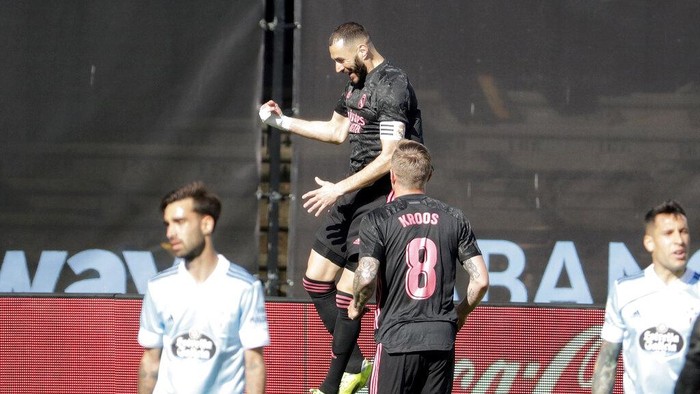 Real Madrids Karim Benzema, centre, celebrates after scoring his sides opening goal during a Spanish La Liga soccer match between Celta and Real Madrid at the Balaidos stadium in Vigo, Spain, Saturday March 20, 2021. (AP Photo/Lalo R.Villar)