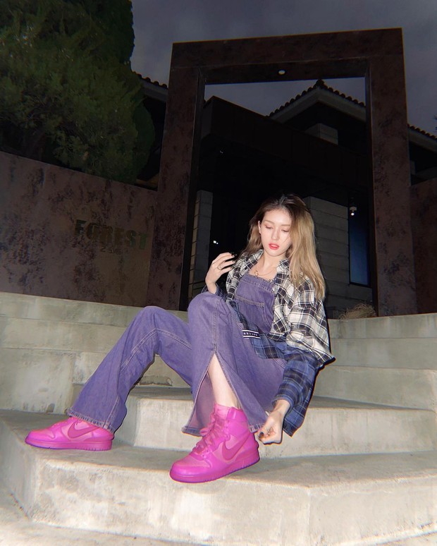 Denim Overall/instagram.com/somsomi0309 Ia memadukan denim overall berwarna ungu dengan checked oversized shirt dan memasangkannya dengan sepatu AMBUSH x Nike Dunk High berwarna pink.