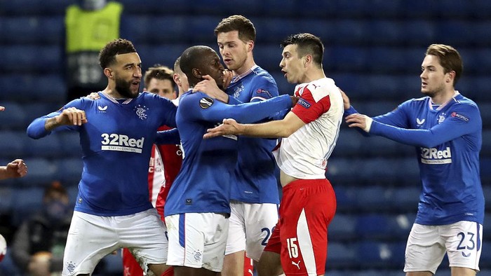 Rangers Glen Kamara, center, is held back by teammates as he reacts near the end of the Europa League Round of Sixteen soccer match between Rangers and Slavia Prague, at Ibrox Stadium, in Glasgow, Scotland,  Thursday March 18, 2021. (Andrew Milligan/PA via AP)