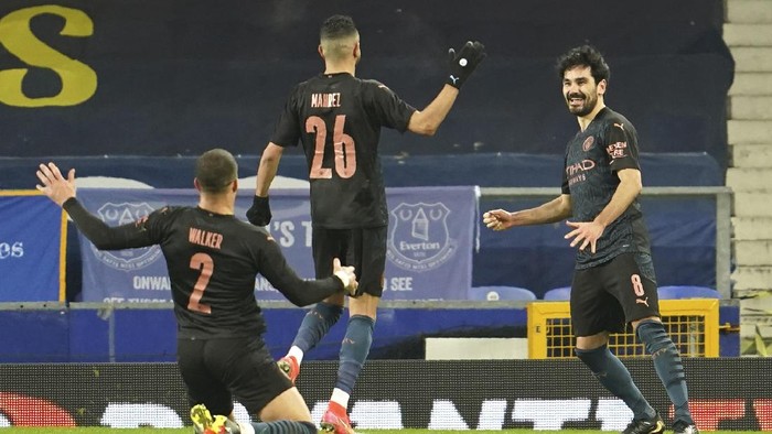 Manchester Citys Ilkay Gundogan, right, celebrates after scoring his sides opening goal during the English FA Cup sixth round soccer match between Everton and Manchester City at Goodison Park in Liverpool, England, Saturday, March 20, 2021. (AP Photo/Jon Super, Pool)