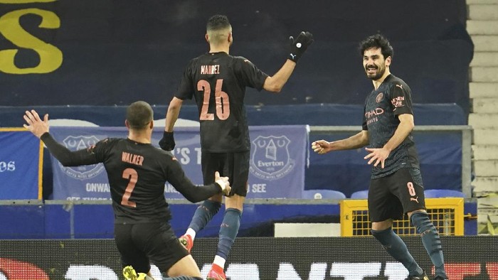 Manchester Citys Ilkay Gundogan, right, celebrates after scoring his sides opening goal during the English FA Cup sixth round soccer match between Everton and Manchester City at Goodison Park in Liverpool, England, Saturday, March 20, 2021. (AP Photo/Jon Super, Pool)