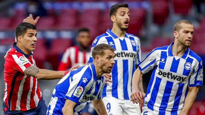 Atletico Madrids Luis Suarez, left, in action during the Spanish La Liga soccer match between Atletico Madrid and Alaves at the Wanda Metropolitano stadium in Madrid, Spain, Sunday, March 21, 2021. (AP Photo/Manu Fernandez)