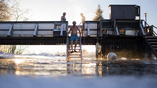 Finns take a dip in an unfrozen hole of water after a sauna session on January 15, 2017 in Vaasa, as air temperature is -17C and water is +1C. (Photo by OLIVIER MORIN / AFP)
