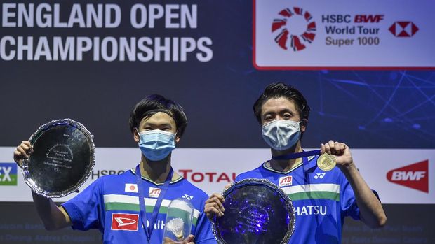 Japan's Yuta Watanabe, left, and Hiroyuki Endo celebrate at the podium after winning the men's doubles final match of the All England Open Badminton Championships at the Utilita Arena in Birmingham, England, Sunday March 21, 2021. (AP Photo/Rui Vieira)