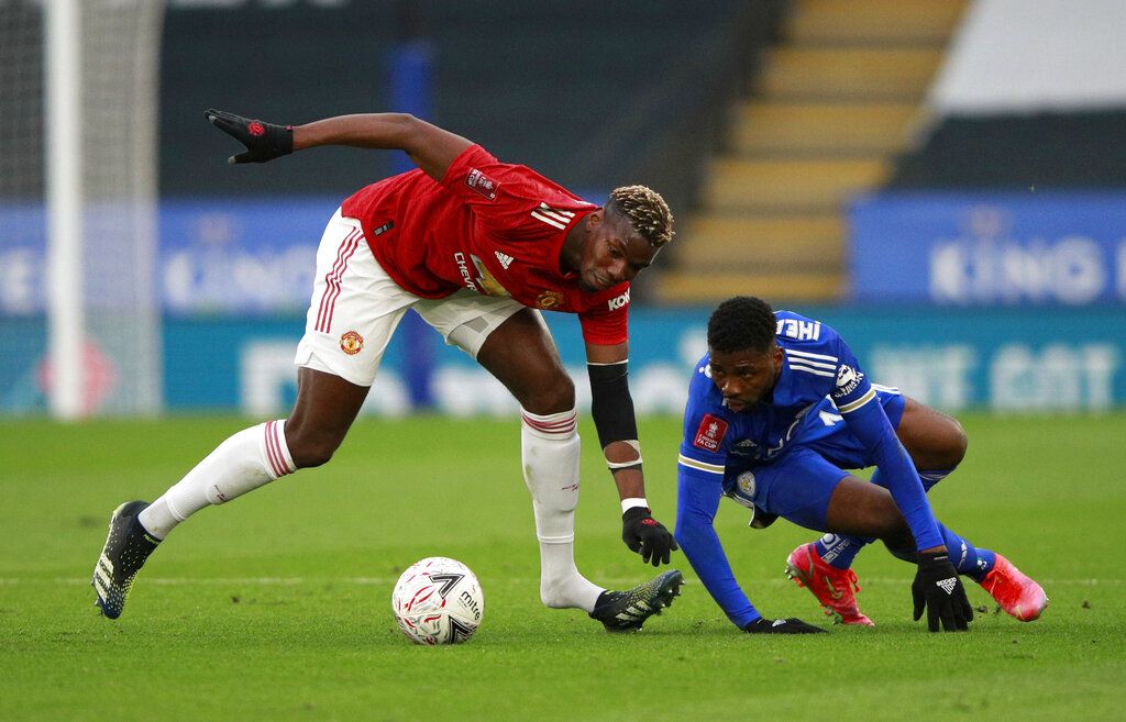 Manchester United's Paul Pogba, left, duels for the ball with Leicester's Kelechi Iheanacho during the English FA Cup quarter final soccer match between Leicester City and Manchester United at the King Power Stadium in Leicester, England, Sunday, March 21, 2021. (AP Photo/Ian Walton, Pool)