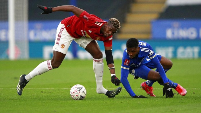Manchester Uniteds Paul Pogba, left, duels for the ball with Leicesters Kelechi Iheanacho during the English FA Cup quarter final soccer match between Leicester City and Manchester United at the King Power Stadium in Leicester, England, Sunday, March 21, 2021. (AP Photo/Ian Walton, Pool)