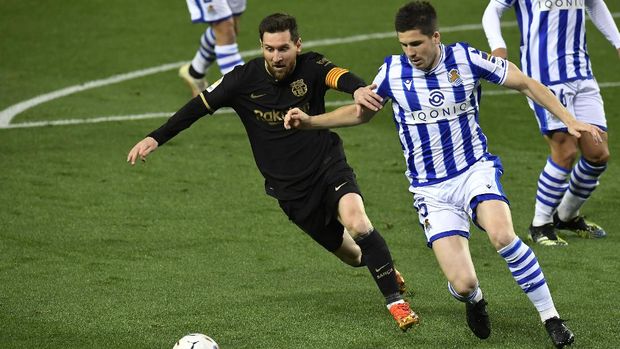 Barcelona's Lionel Messi fights for the ball against Real Sociedad's Igor Zubeldia during the Spanish La Liga soccer match between Real Sociedad and FC Barcelona at Reale Arena stadium in San Sebastian, Spain, Sunday, March. 21, 2021. (AP Photo/Alvaro Barrientos)