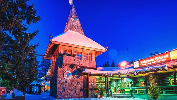 Santa Claus' Main Post Office Rovaniemi, Finland - March 6, 2017: Santa Claus Main Post Office at Santa Village with Christmas trees. Lapland, Finland, Scandinavia, on Arctic Circle in winter. Night. Outdoor