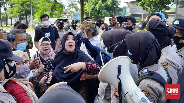 Dua orang simpatisan Rizieq Shihab dipaksa menyingkir dari pintu gerbang Pengadilan Negeri Jakarta Timur. Kurnia, ibu ibu yang mengenakan kerudung hitam mengaku sebagai bagian dari kuasa hukum Rizieq, Senin (23/3).