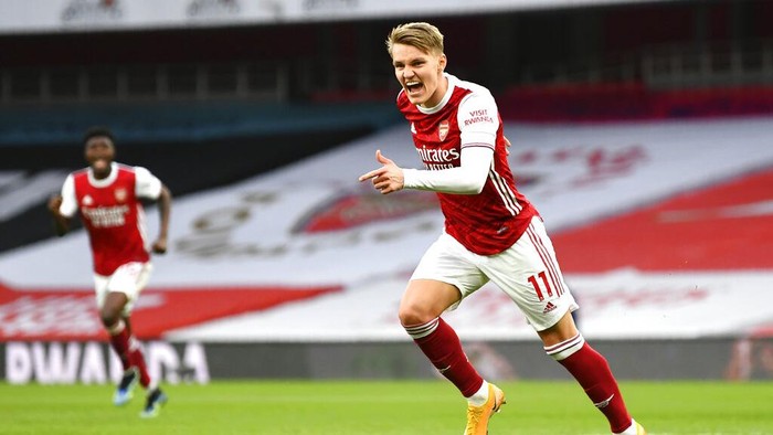 Arsenals Martin Odegaard celebrates after scoring his sides opening goal during the English Premier League soccer match between Arsenal and Tottenham Hotspur at the Emirates stadium in London, England, Sunday, March 14, 2021. (Dan Mullan/Pool via AP)