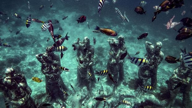Ikan-ikan berada di dekat patung karya seniman Jason deCaires Taylor berjudul Nest di perairan Gili Meno. ANTARA FOTO/Aprillio Akbar
