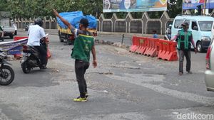 Pak Ogah Beraksi di Atas Jl Raya Legok-Karawaci yang Rusak