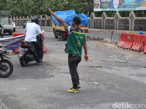 Pak Ogah Beraksi di Atas Jl Raya Legok-Karawaci yang Rusak