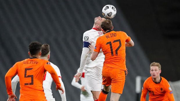 Turkey's forward Burak Yilmaz (C) heads the ball with Netherlands' defender Daley Blind (17) during the FIFA World Cup Qatar 2022 qualification Group G football match between Turkey and The Netherlands at the Ataturk Olympic Stadium, in Istanbul, on March 24, 2021. (Photo by MURAD SEZER / POOL / AFP)